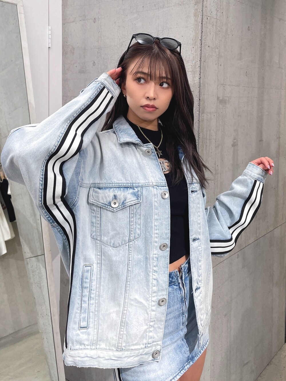 ブルー系のデニムスカート、ブラック系のブーツ、ブラック系のTシャツ/カットソーを着用したレディースの春コーディネートの5枚目の写真