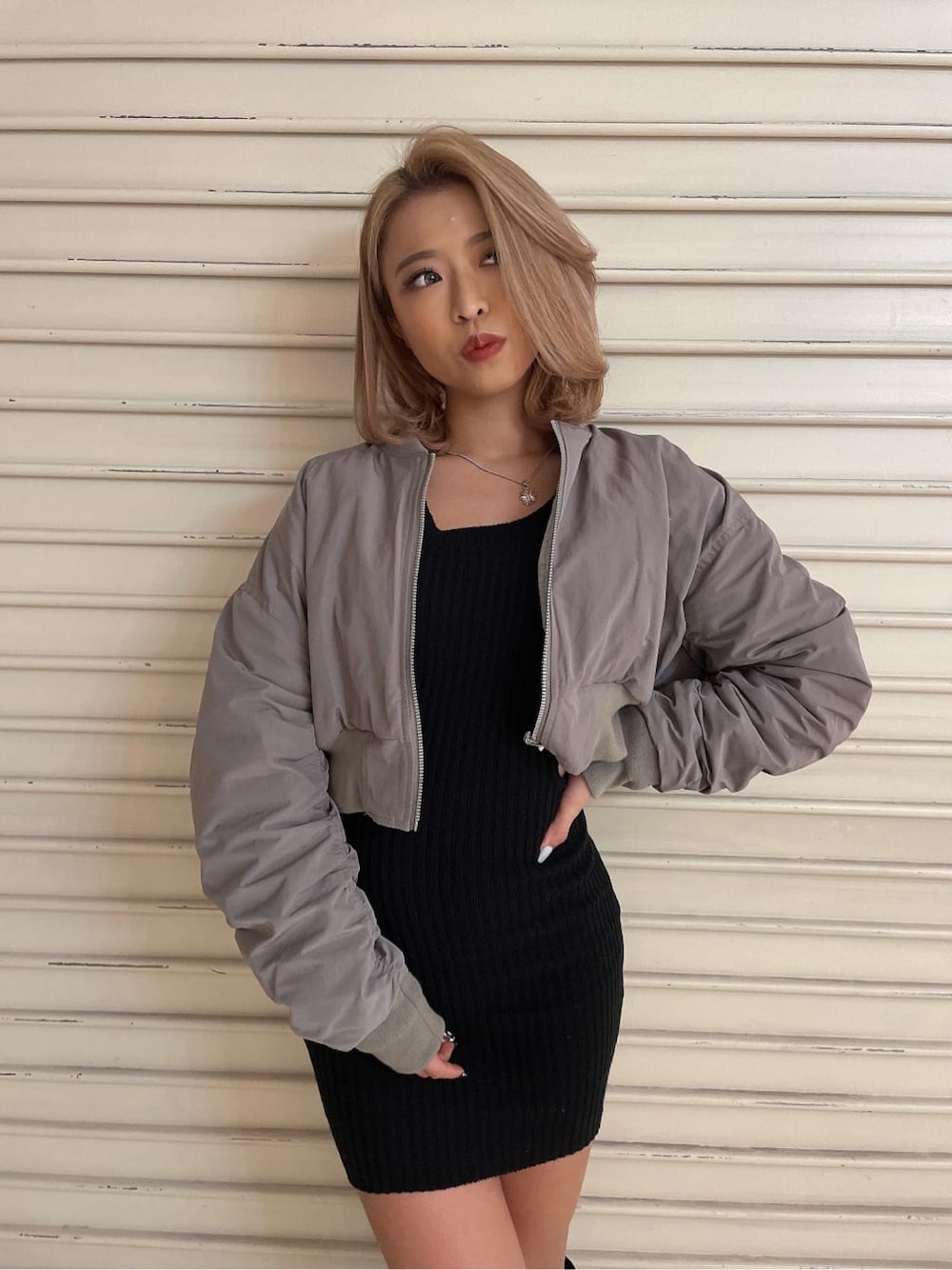 ブラック系のブーツ、グレー系のMA-1、ブラック系のワンピースを着用したレディースの冬コーディネートの2枚目の写真