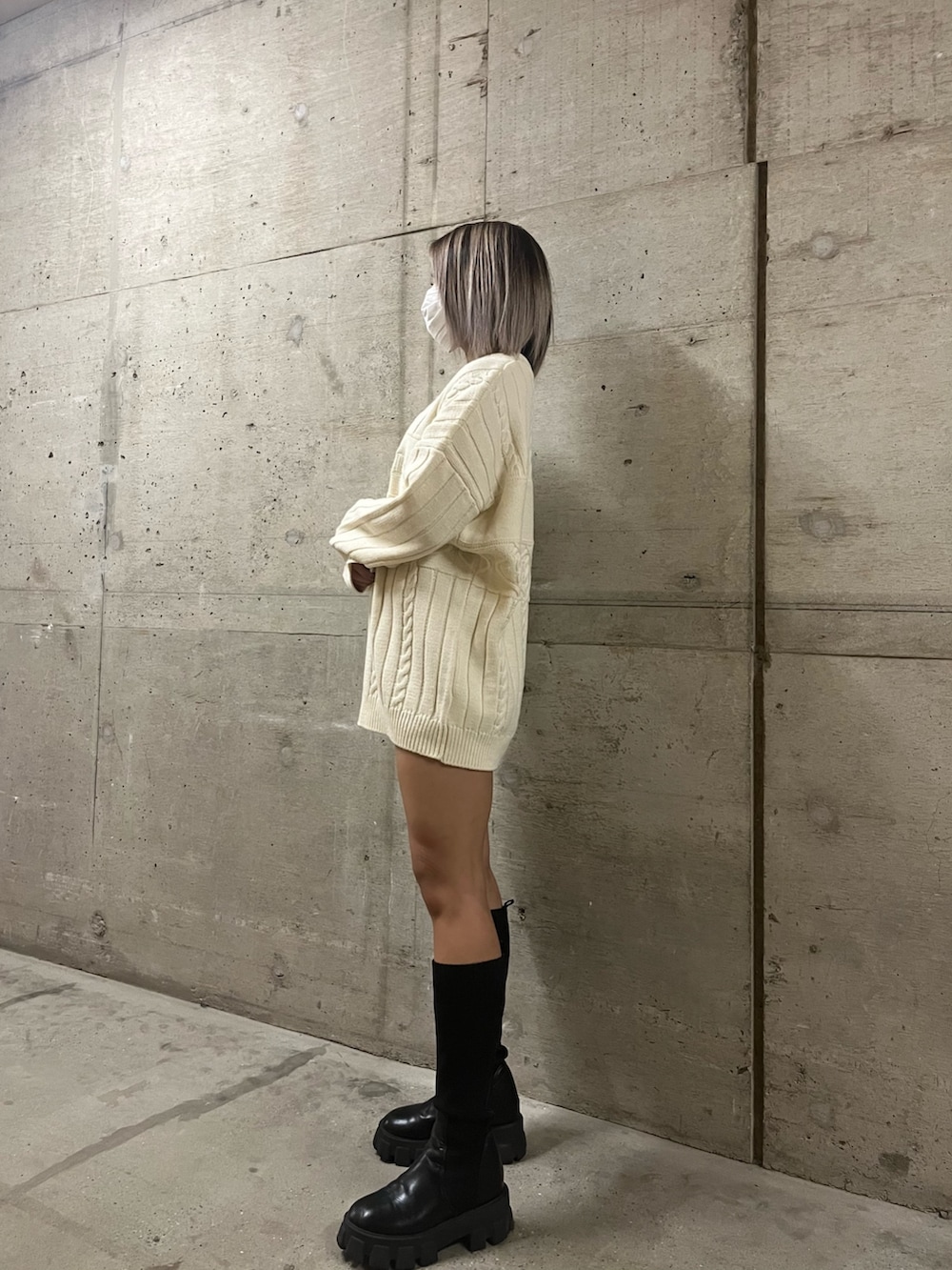 グリーン系のニット/セーター、ホワイト系のニット/セーター、ブラック系のブーツを着用したレディースの秋コーディネートの4枚目の写真