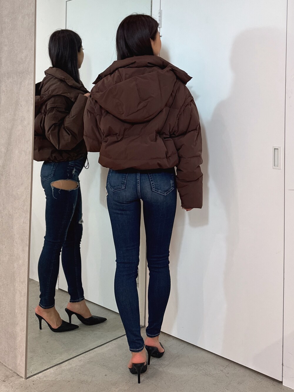 ホワイト系のTシャツ/カットソー、ブラウン系のダウンジャケット/コート、ブルー系のデニムパンツを着用したレディースの秋コーディネートの4枚目の写真