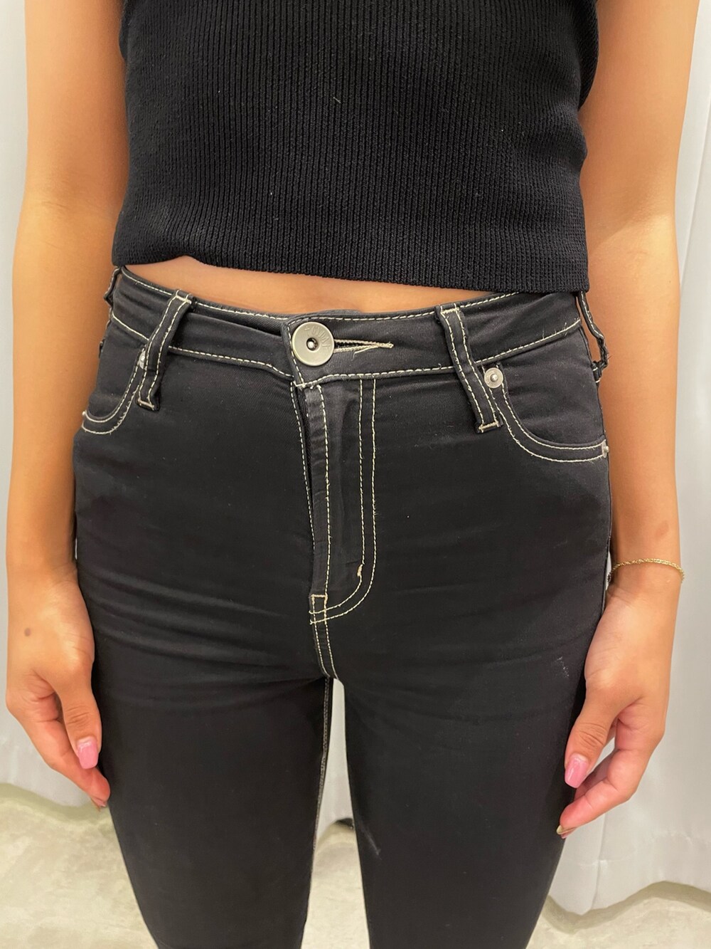 ブラック系のニット/セーター、ブラック系のデニムパンツ、ホワイト系のパンプスを着用したレディースの夏コーディネートの6枚目の写真