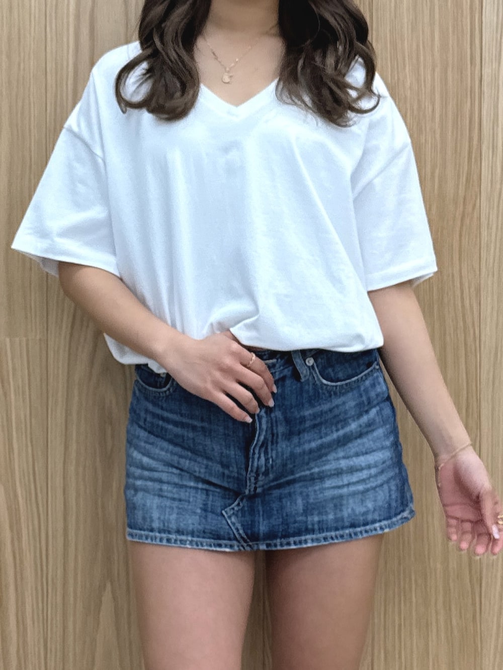 ホワイト系のTシャツ/カットソー、ブルー系のデニムスカート、ブラック系のブーツを着用したレディースの春コーディネートの5枚目の写真