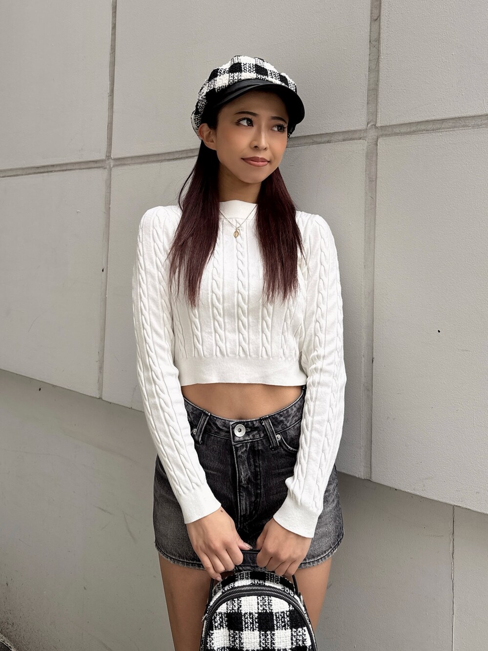 ホワイト系のニット/セーター、ブラック系のデニムスカート、その他のバックパック/リュックを着用したレディースの秋コーディネートの4枚目の写真