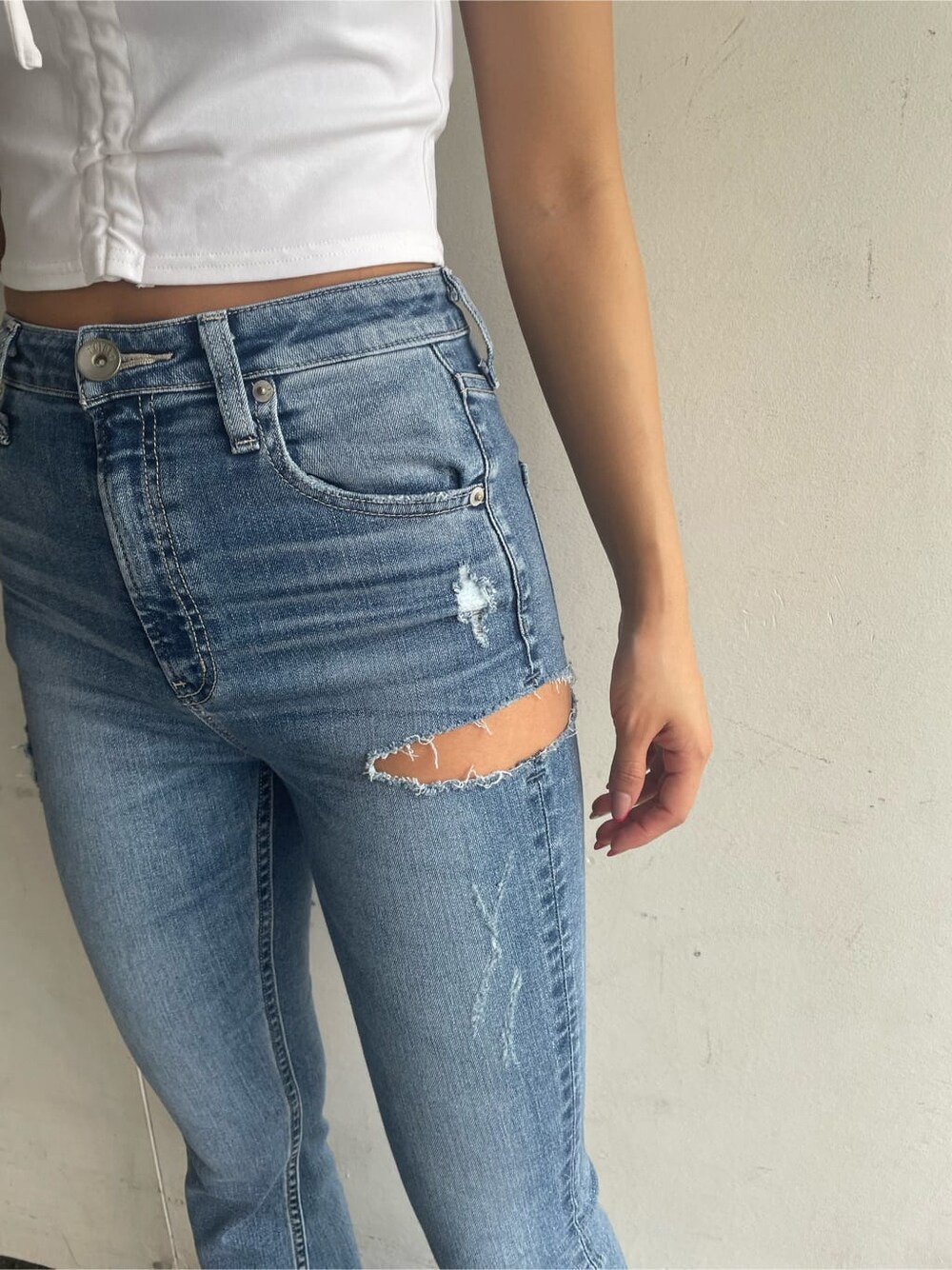 ブラック系のパンプス、グレー系のハンドバッグ、ブルー系のデニムパンツを着用したレディースの春コーディネートの7枚目の写真