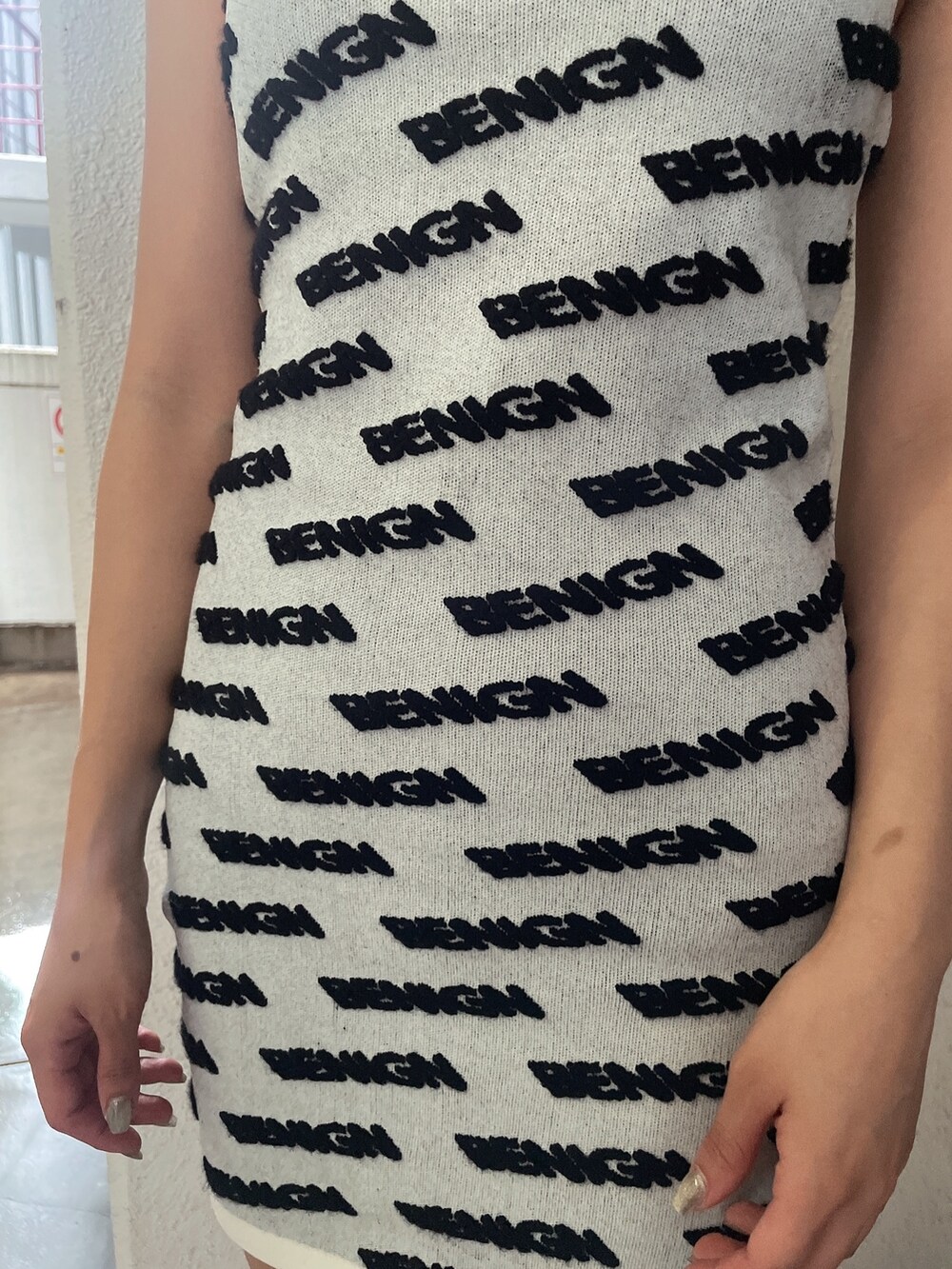 ホワイト系のワンピース、ブラック系のブルゾン、ブラック系のブーツを着用したレディースの夏コーディネートの5枚目の写真