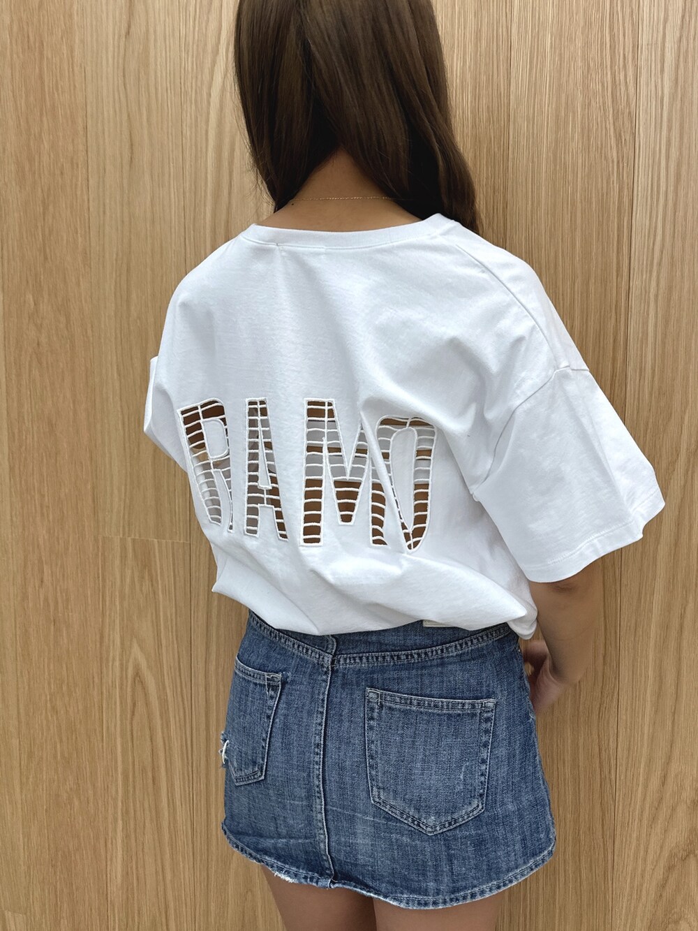 ホワイト系のTシャツ/カットソー、ブルー系のデニムスカート、ブラック系のブーツを着用したレディースの春コーディネートの6枚目の写真