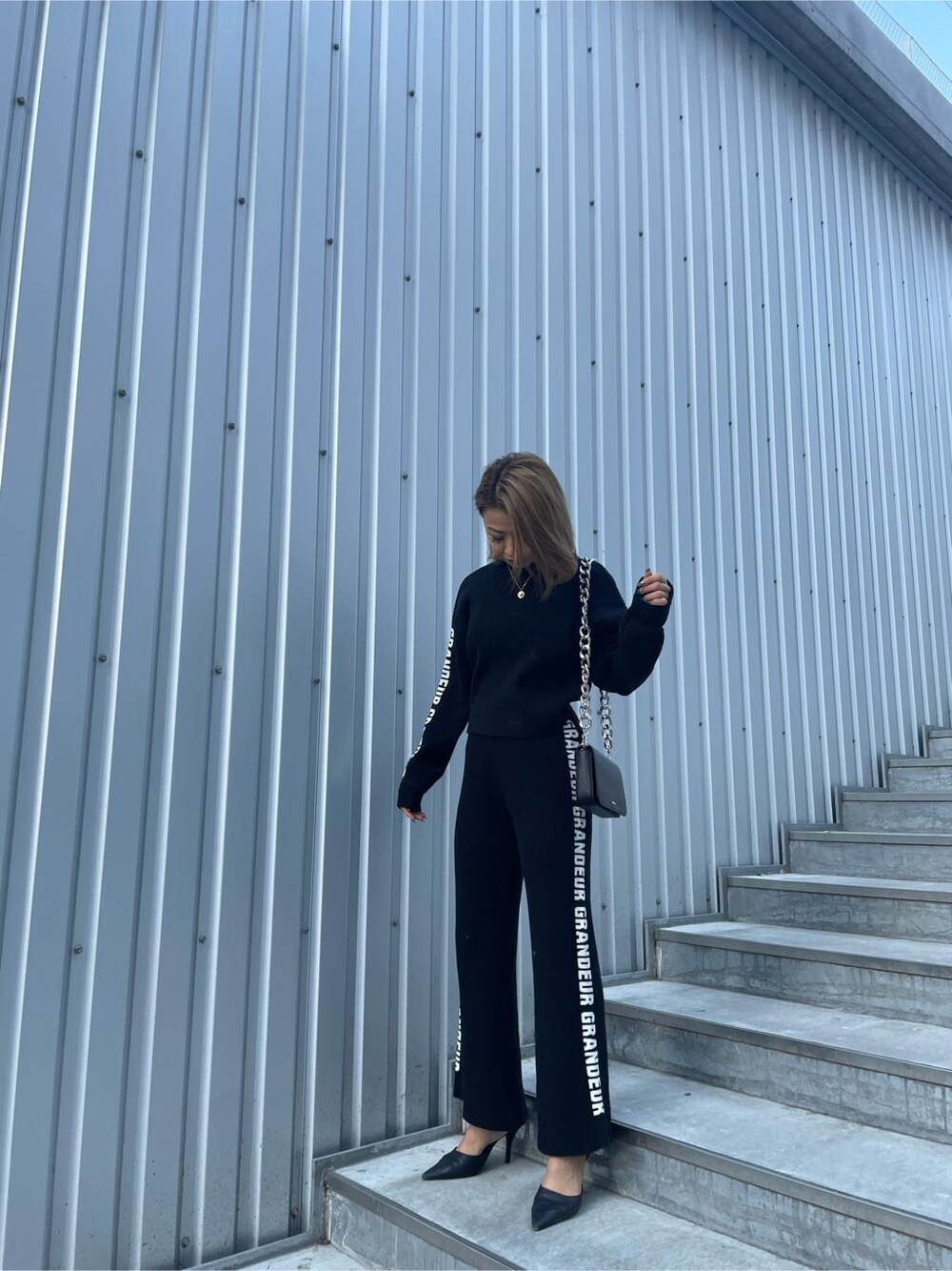 ブラック系のその他パンツ、ブラック系のパンプス、ブラック系のニット/セーターを着用したレディースの冬コーディネートの2枚目の写真