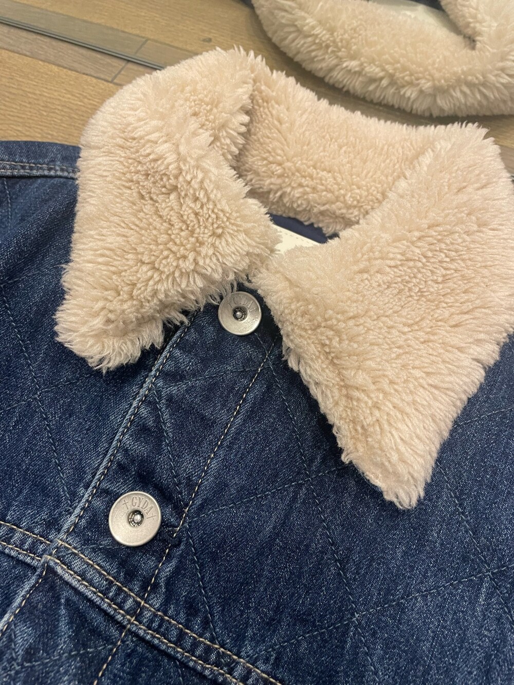 ブルー系のデニムパンツ、ブラック系のブーツ、ブルー系のデニムジャケットを着用したレディースの秋コーディネートの6枚目の写真