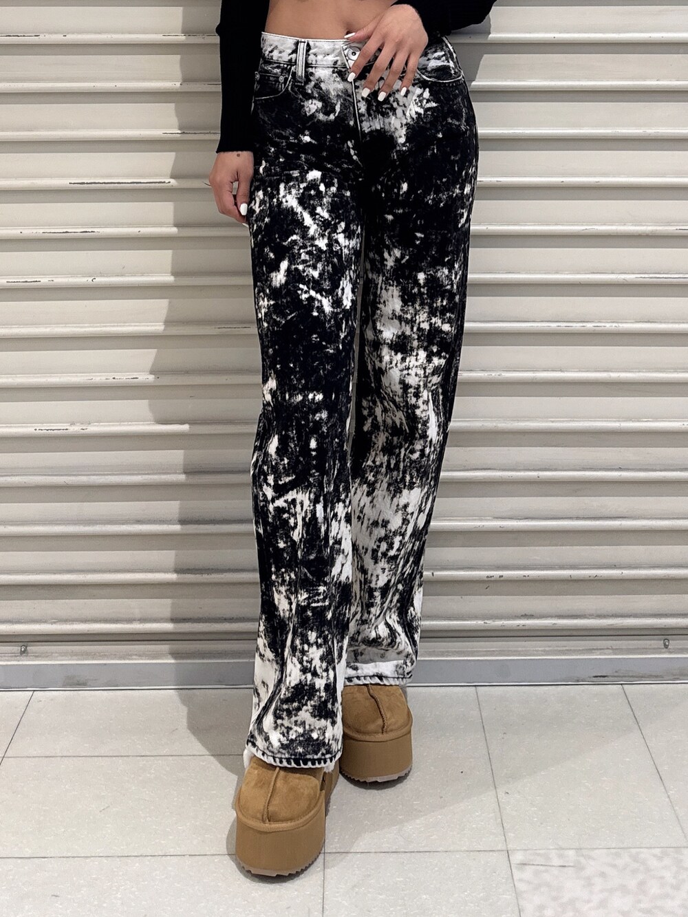 ブラック系のニット/セーター、ブラック系のデニムパンツ、ベージュ系のブーツを着用したレディースの秋コーディネートの5枚目の写真