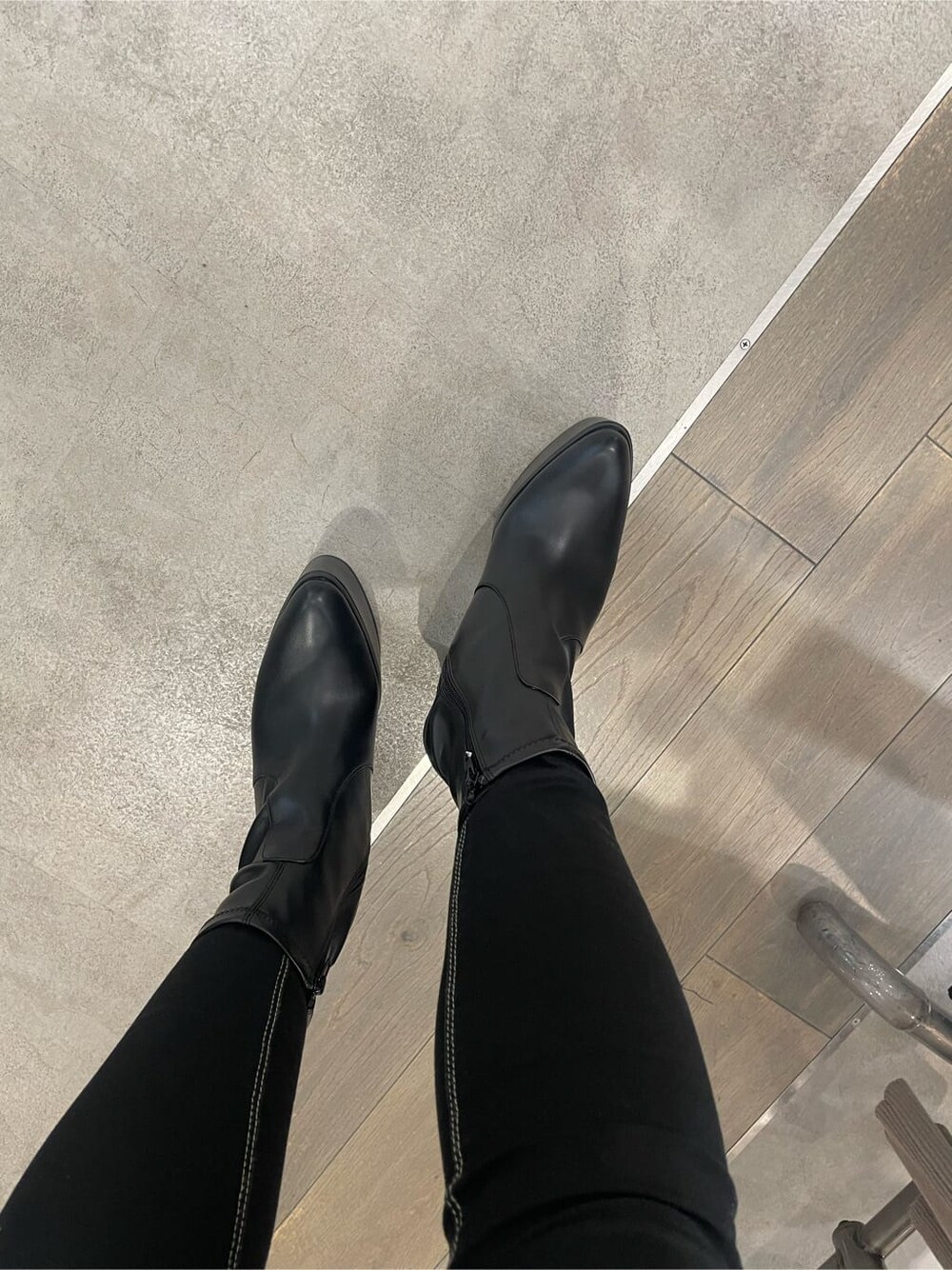 ブラック系のデニムパンツ、グレー系のスウェット、ブラック系のブーツを着用したレディースの秋コーディネートの9枚目の写真