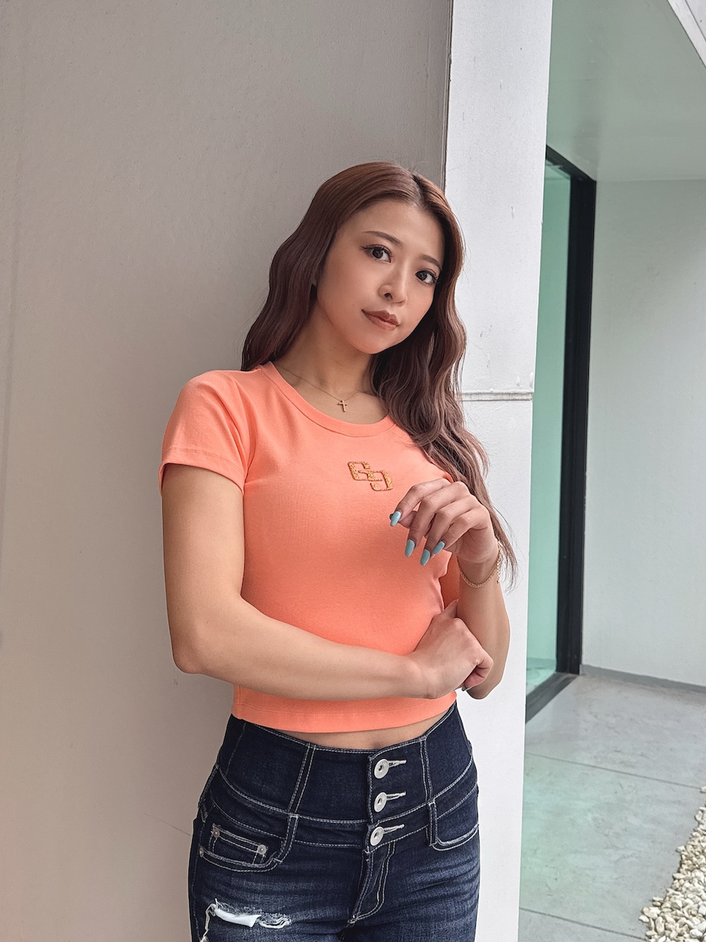 オレンジ系のTシャツ/カットソー、ブルー系のデニムパンツ、ブラック系のパンプスを着用したレディースの春コーディネートの6枚目の写真