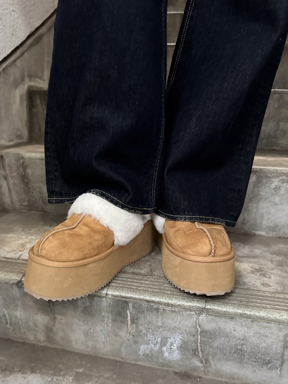 ホワイト系のニット/セーター、ブルー系のデニムパンツ、ベージュ系のスリッポンを着用したレディースの冬コーディネートの5枚目の写真