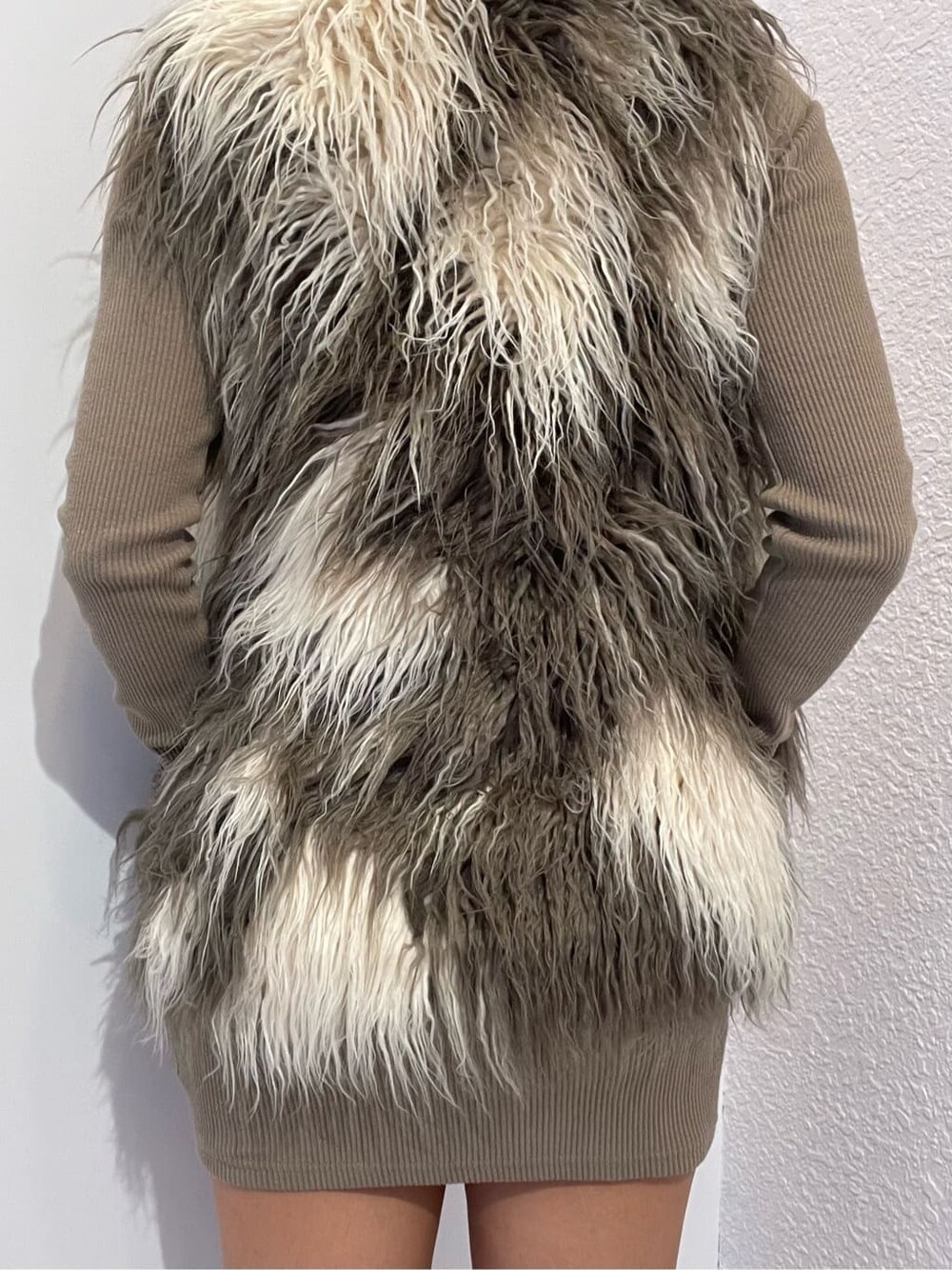 ベージュ系のワンピース、その他のベスト、ブラック系のブーツを着用したレディースの秋コーディネートの6枚目の写真