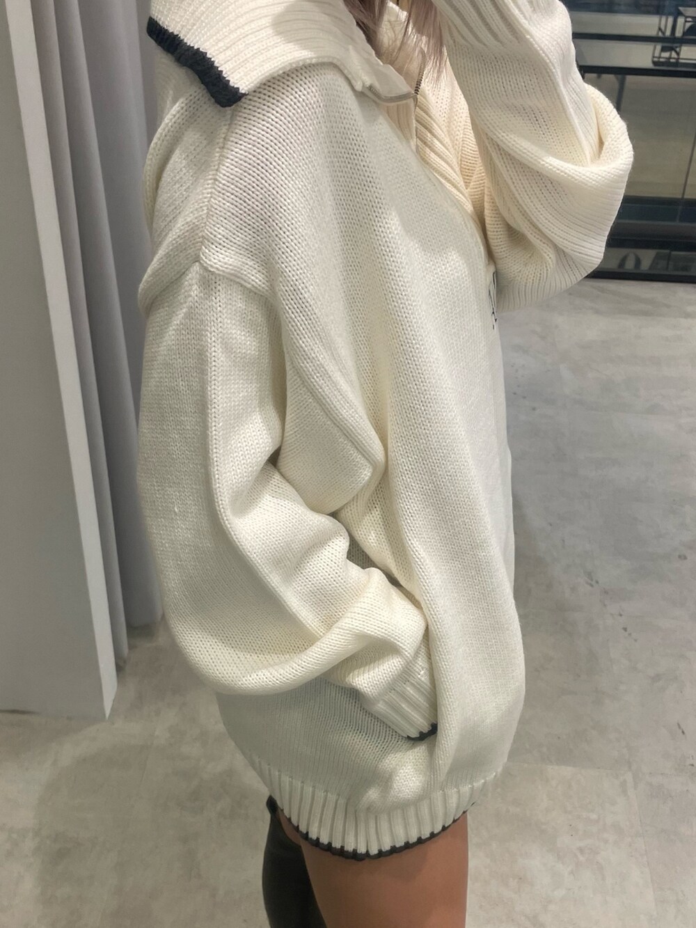 ホワイト系のニット/セーター、ブラック系のスカート、ブラック系のブーツを着用したレディースの冬コーディネートの5枚目の写真