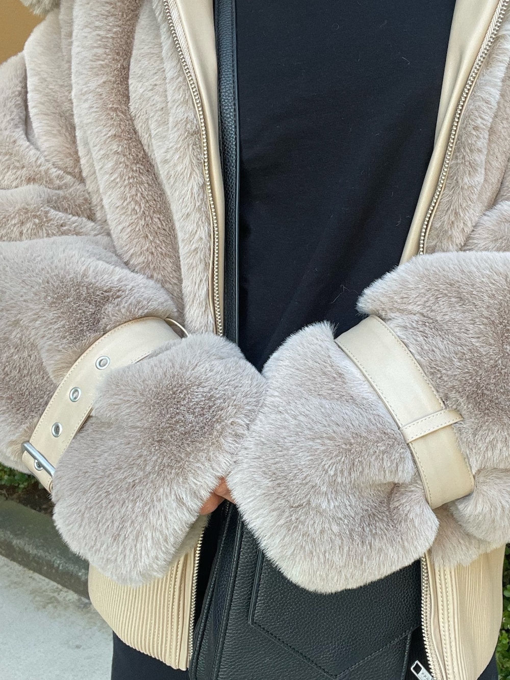 ベージュ系のブルゾン、ブラック系のワンピース、ブラック系のブーツを着用したレディースの冬コーディネートの7枚目の写真