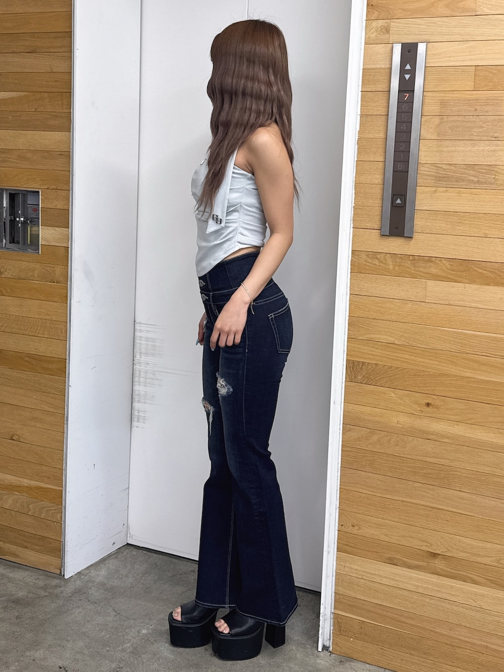 ブルー系のチューブトップ、ブルー系のデニムパンツ、ブラック系のサンダルを着用したレディースの春コーディネートの4枚目の写真