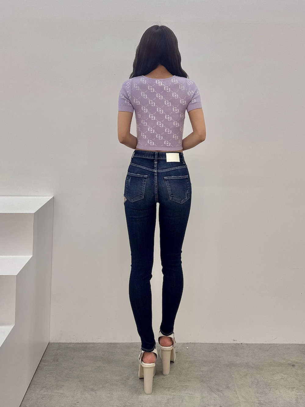 パープル系のTシャツ/カットソー、ブルー系のデニムパンツ、ホワイト系のサンダルを着用したレディースの春コーディネートの3枚目の写真
