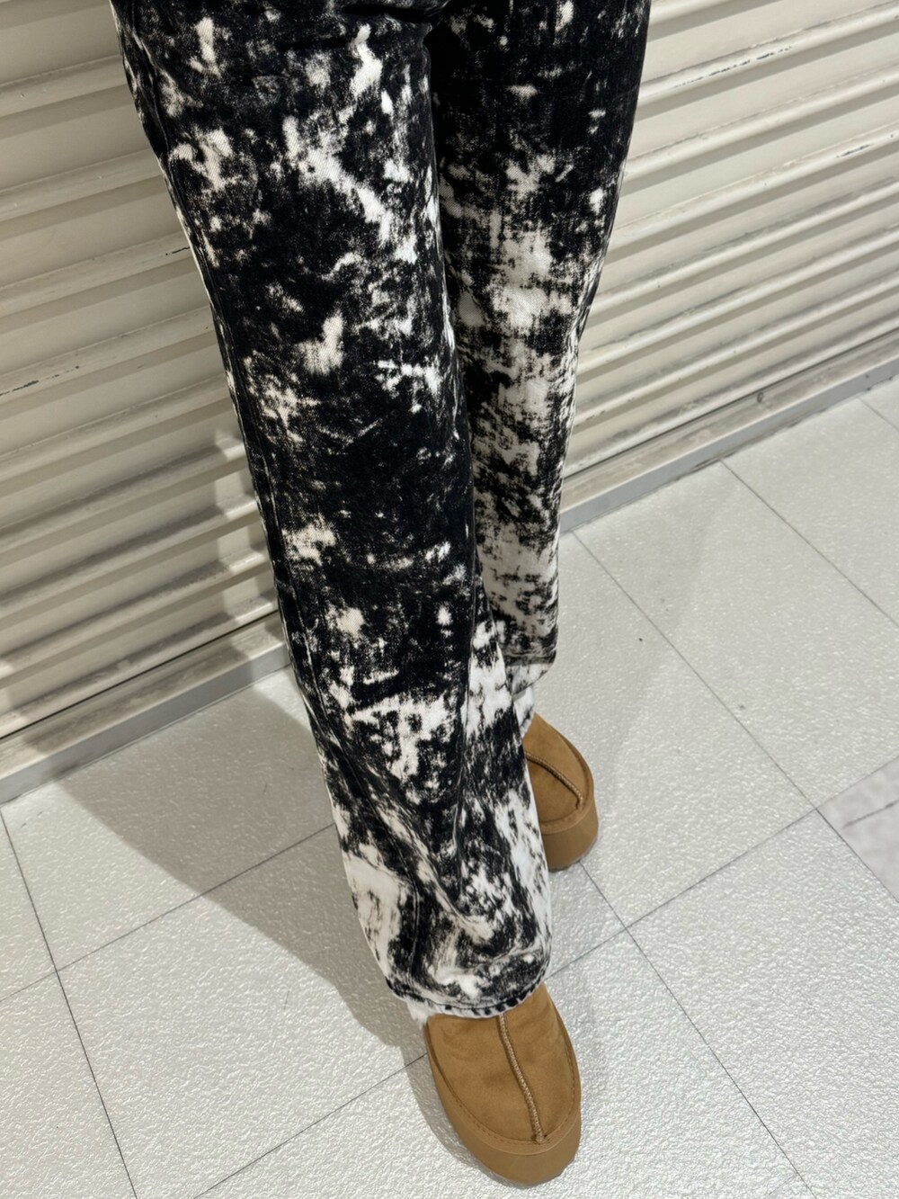 ブラック系のニット/セーター、ブラック系のデニムパンツ、ベージュ系のブーツを着用したレディースの秋コーディネートの6枚目の写真