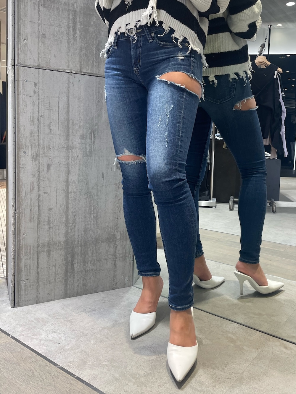 ブルー系のデニムパンツ、ホワイト系のパンプス、ブラック系のニット/セーターを着用したレディースの冬コーディネートの5枚目の写真