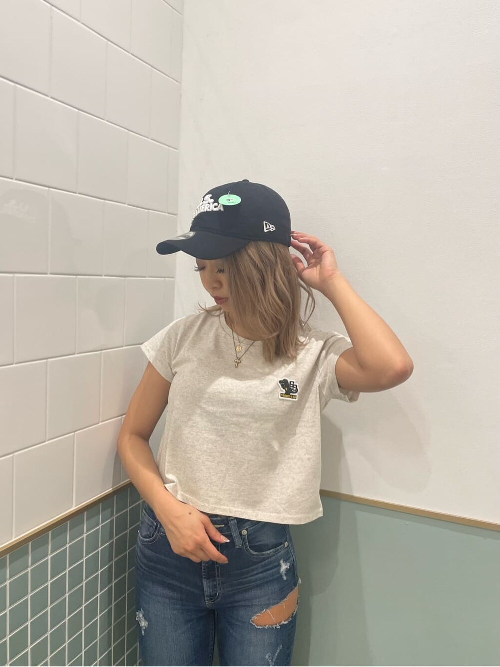 ブラック系のパンプス、グレー系のTシャツ/カットソー、ブルー系のデニムパンツを着用したレディースの春コーディネートの4枚目の写真