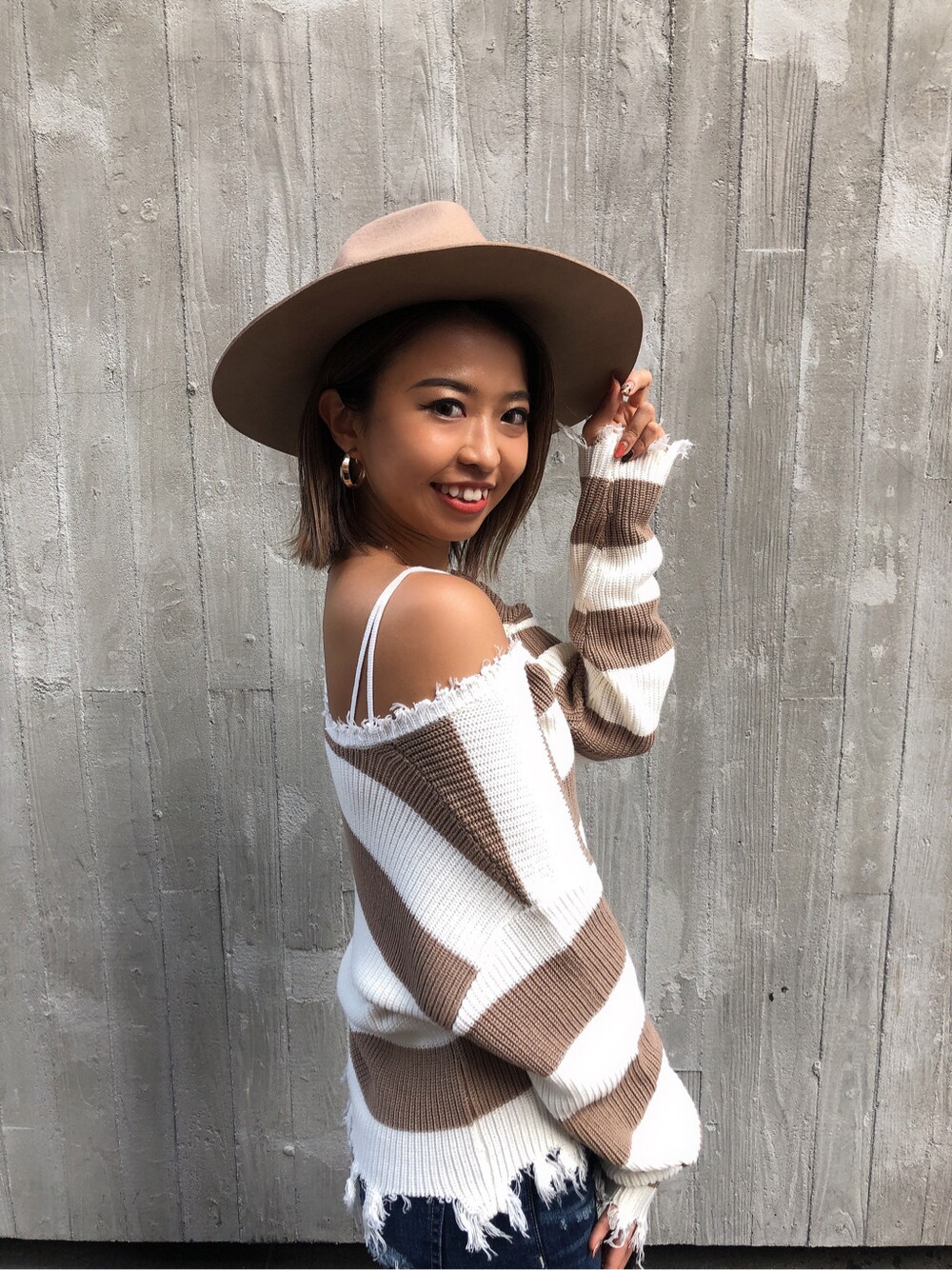 ベージュ系のニット/セーター、ホワイト系のキャミソール、ブラック系のパンプスを着用したレディースの秋コーディネートの2枚目の写真