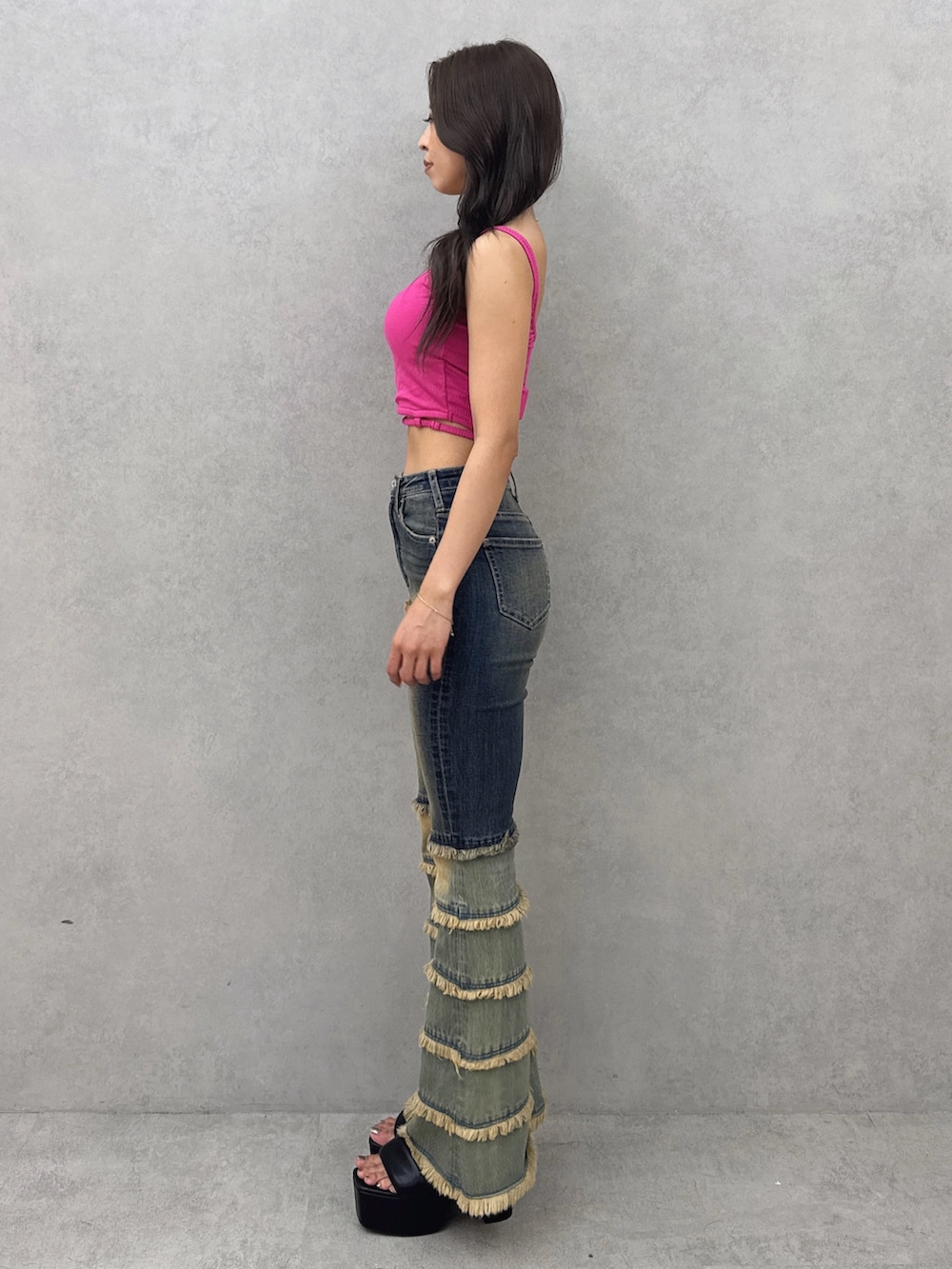 ピンク系のキャミソール、ブルー系のデニムパンツ、ブラック系のサンダルを着用したレディースの夏コーディネートの2枚目の写真