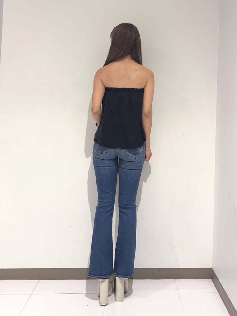 ホワイト系のサンダル、ブルー系のデニムパンツ、ブラック系のチューブトップを着用したレディースの夏コーディネートの3枚目の写真
