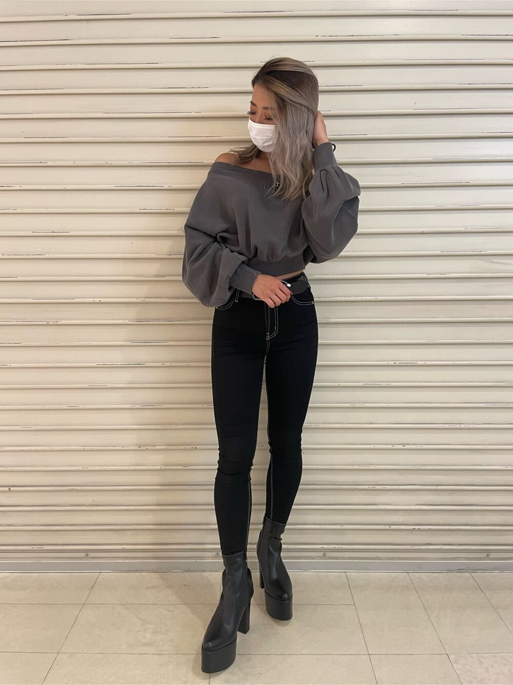 ブラック系のデニムパンツ、グレー系のスウェット、ブラック系のブーツを着用したレディースの秋コーディネートの4枚目の写真