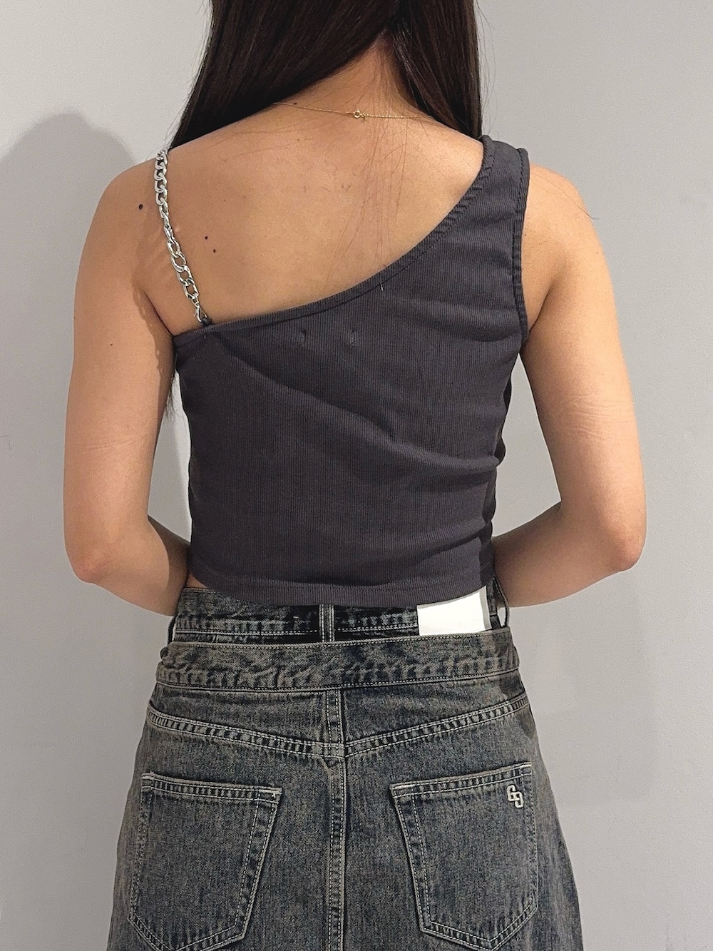 グレー系のタンクトップ、ブルー系のデニムスカート、ホワイト系のサンダルを着用したレディースの夏コーディネートの7枚目の写真