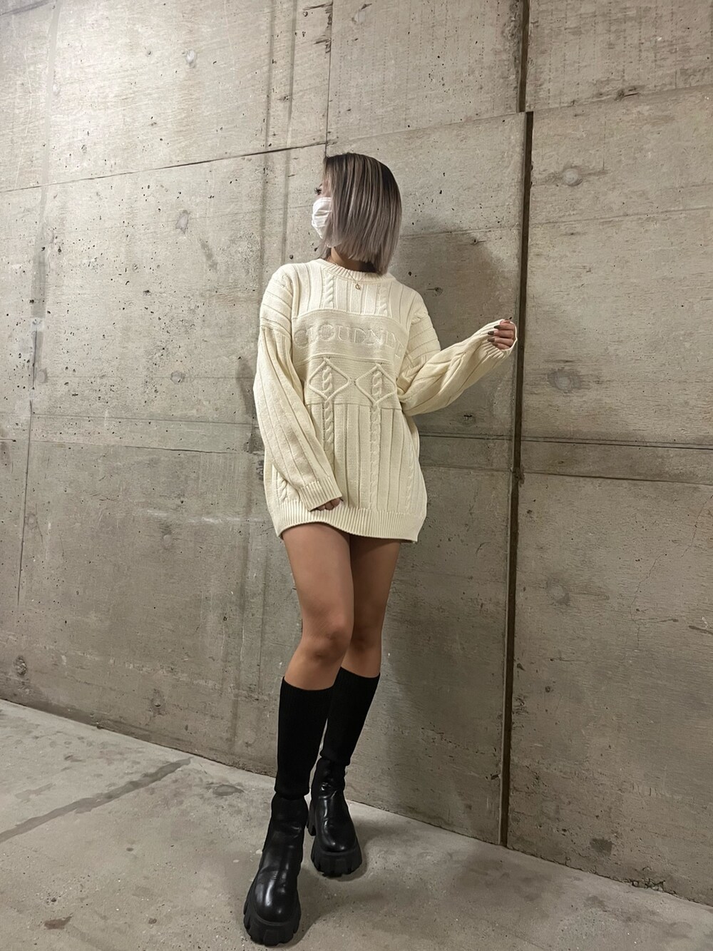 グリーン系のニット/セーター、ホワイト系のニット/セーター、ブラック系のブーツを着用したレディースの秋コーディネートの3枚目の写真