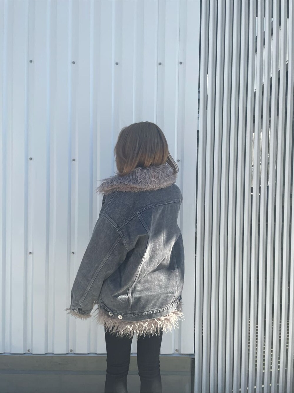 ブラック系のブーツ、ブラック系のデニムパンツ、ホワイト系のニット/セーターを着用したレディースの秋コーディネートの4枚目の写真