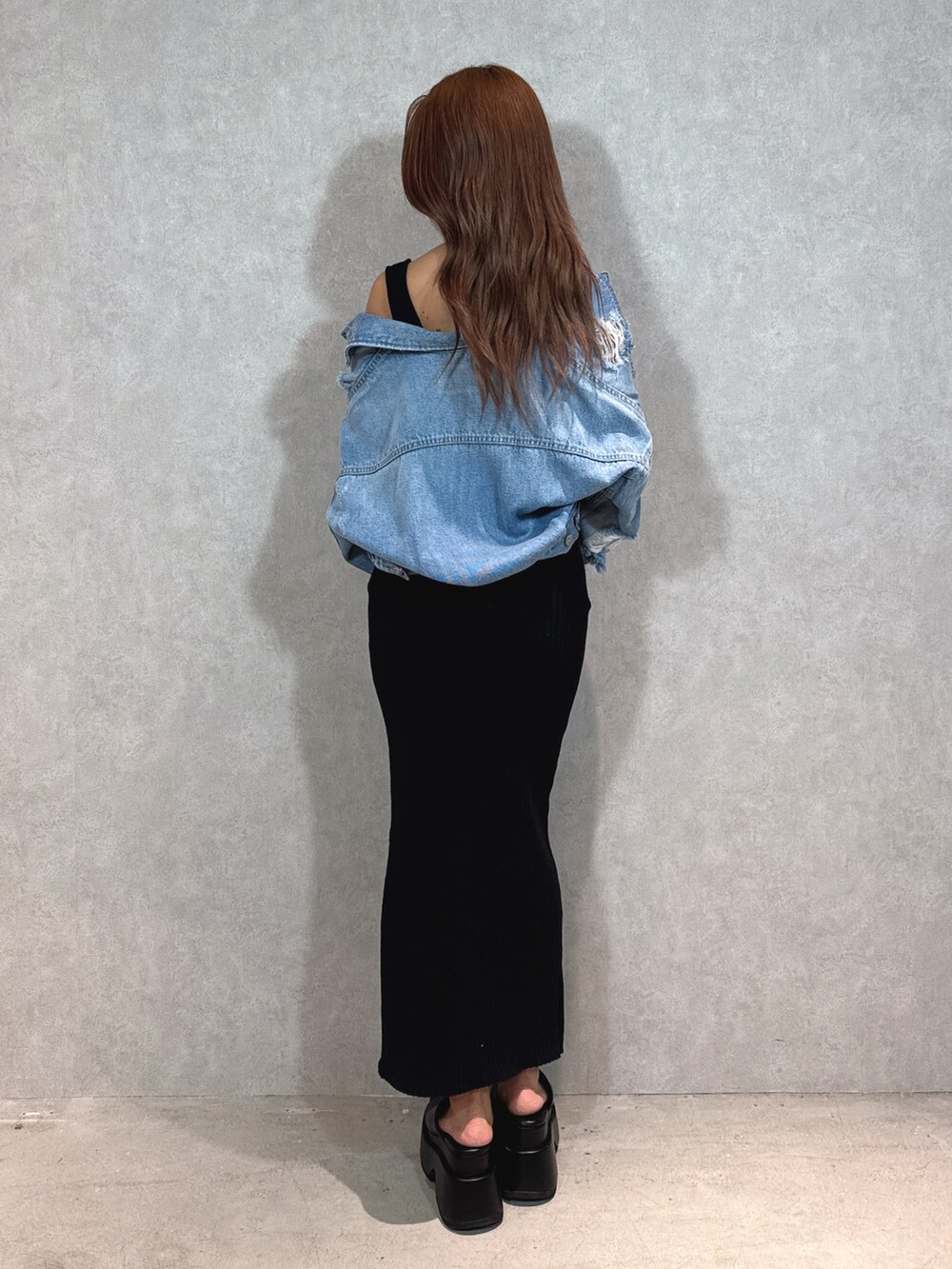 ブラック系のワンピース、ブルー系のデニムジャケット、ブラック系のサンダルを着用したレディースの春コーディネートの4枚目の写真