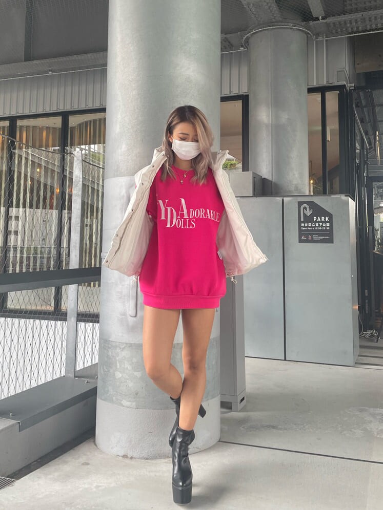 ブルー系のデニムパンツ、ピンク系のスウェット、ブラック系のブーツを着用したレディースの夏コーディネートの2枚目の写真