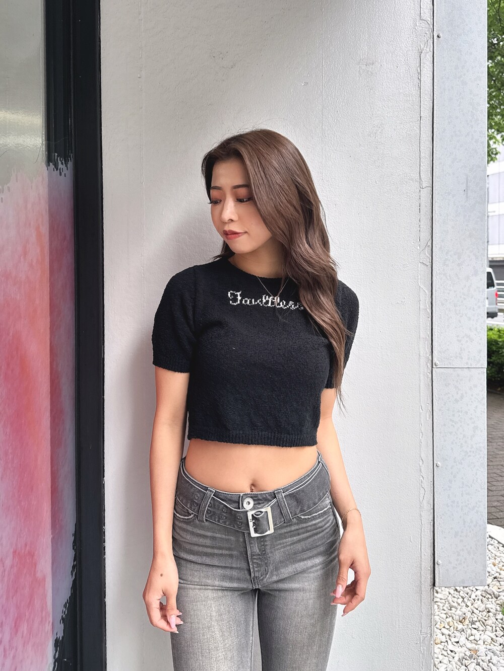 ブラック系のTシャツ/カットソー、ブラック系のデニムパンツ、ホワイト系のパンプスを着用したレディースの春コーディネートの4枚目の写真