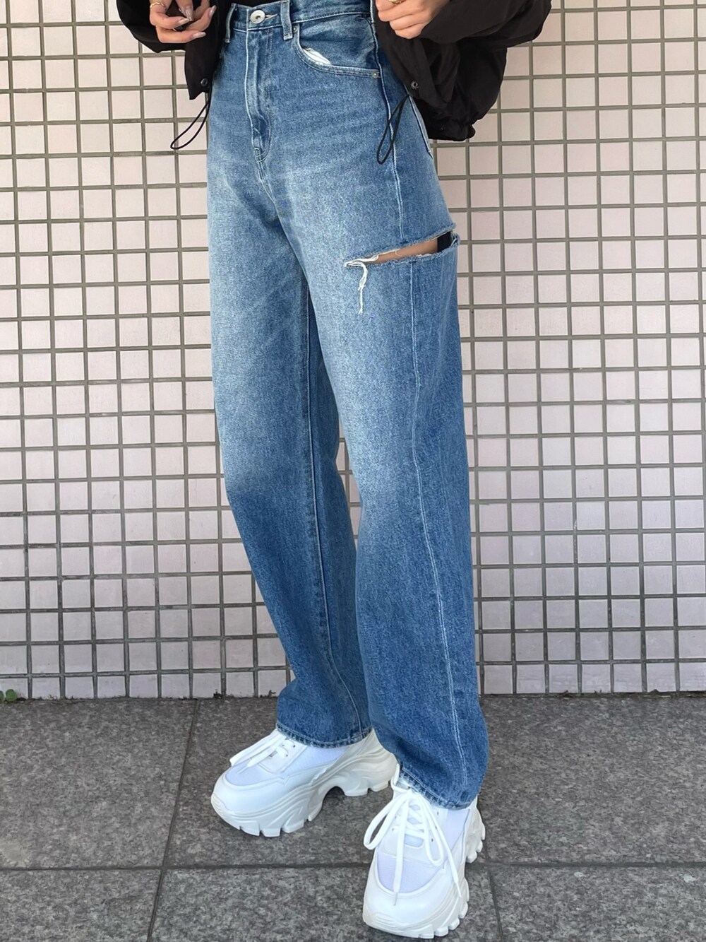 ホワイト系のスニーカー、ブルー系のデニムパンツ、ブラック系のニット/セーターを着用したレディースの冬コーディネートの8枚目の写真