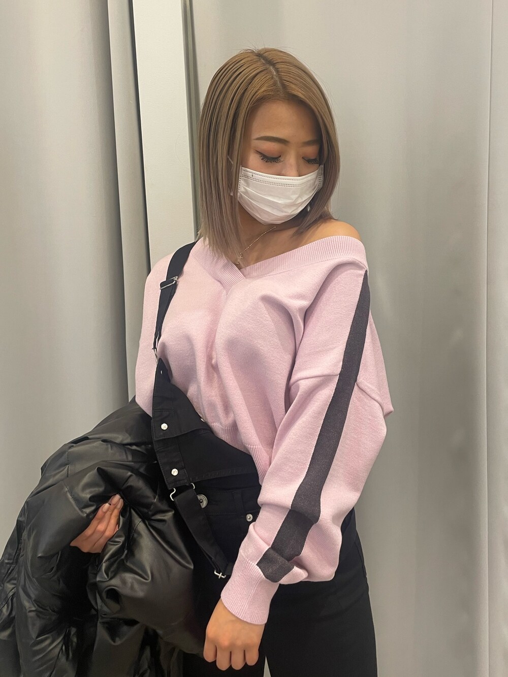 ブラック系のサロペット/オーバーオール、ピンク系のニット/セーター、ブラック系のダウンジャケット/コートを着用したレディースの冬コーディネートの4枚目の写真