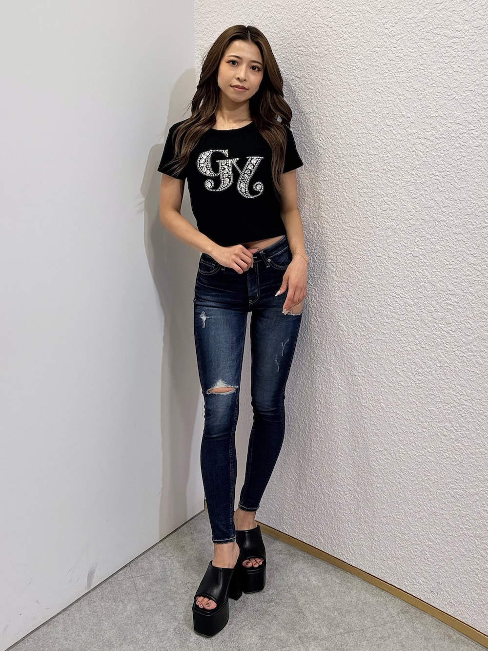 ブラック系のTシャツ/カットソー、ブルー系のデニムパンツ、ブラック系のサンダルを着用したレディースの夏コーディネートの2枚目の写真