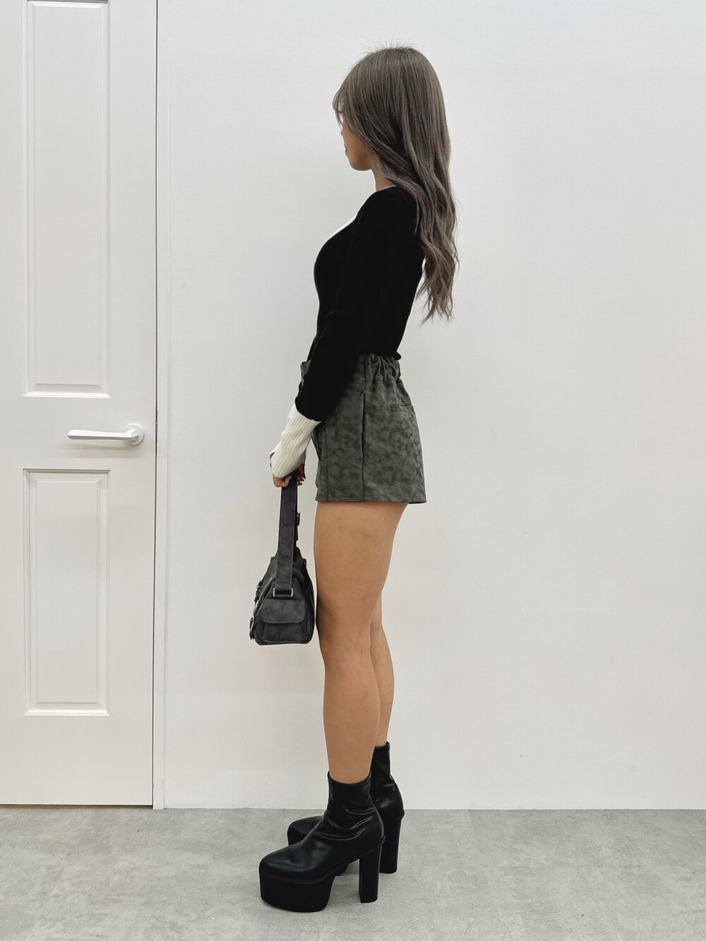 ブラック系のニット/セーター、その他のその他パンツ、グレー系のショルダーバッグを着用したレディースの秋コーディネートの2枚目の写真