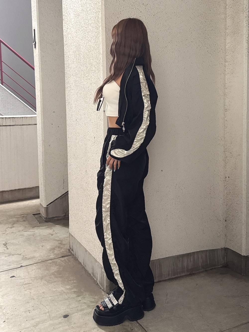 ホワイト系のチューブトップ、ブラック系のブルゾン、ブラック系のその他パンツを着用したレディースの春コーディネートの2枚目の写真