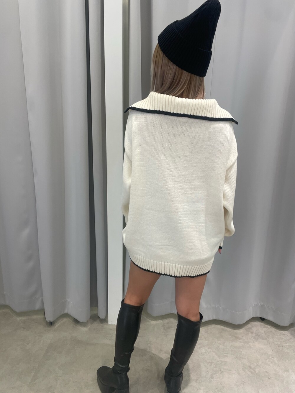 ホワイト系のニット/セーター、ブラック系のスカート、ブラック系のブーツを着用したレディースの冬コーディネートの6枚目の写真