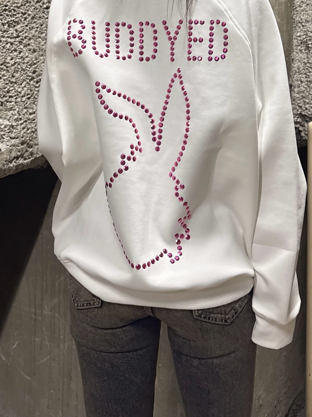 ホワイト系のスウェット、ブルー系のデニムパンツ、ブラック系のブーツを着用したレディースの冬コーディネートの5枚目の写真