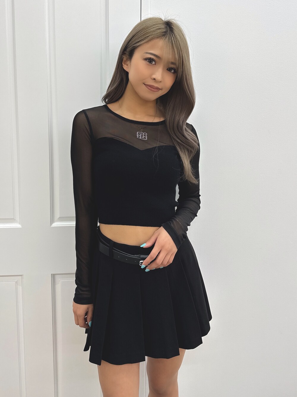 グレー系のスカート、ブラック系のニット/セーター、ブラック系のブーツを着用したレディースの夏コーディネートの5枚目の写真