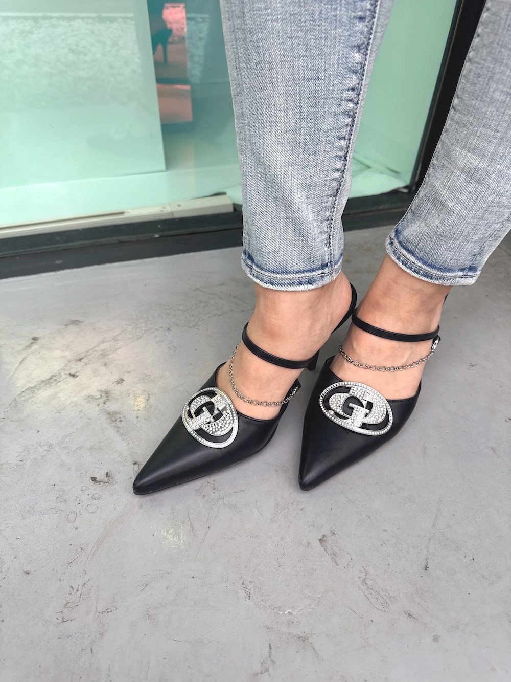 ブラック系のニット/セーター、ブルー系のデニムパンツ、ブラック系のパンプスを着用したレディースの春コーディネートの10枚目の写真