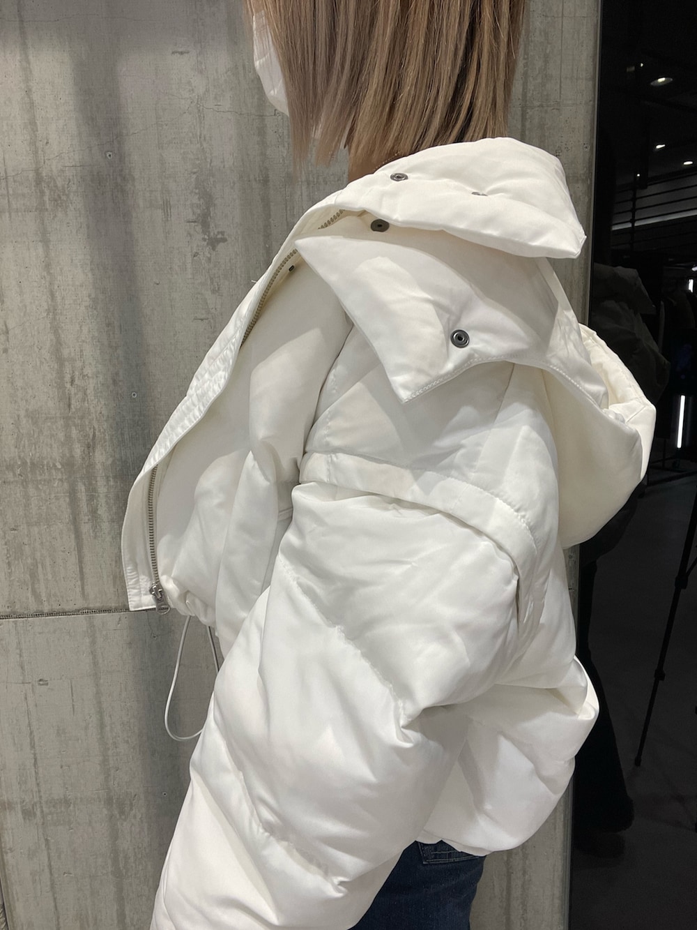 ブルー系のパンツ、ホワイト系のダウンジャケット/コート、ホワイト系のニット/セーターを着用したレディースの冬コーディネートの5枚目の写真