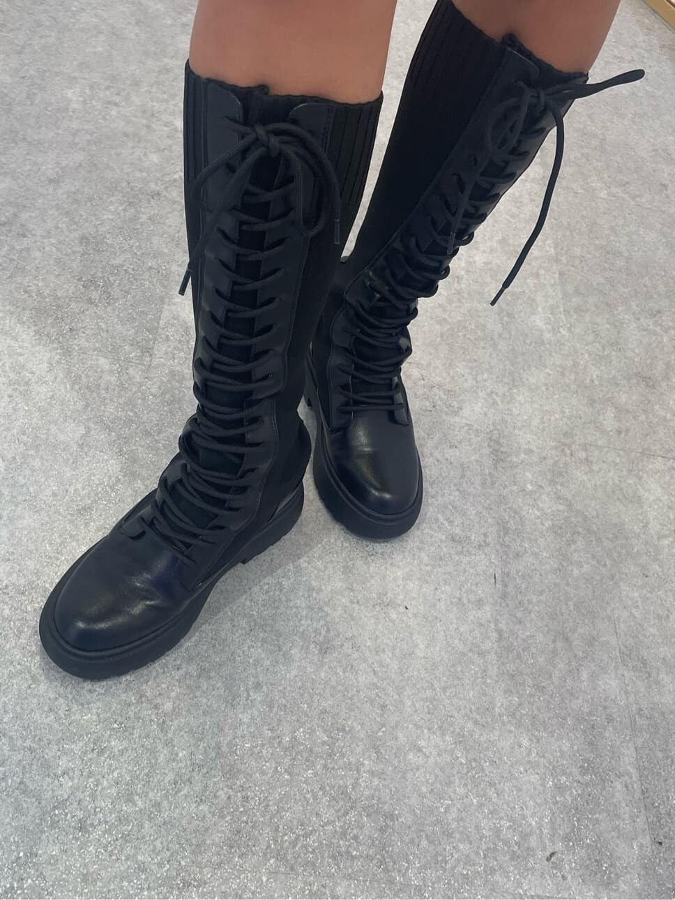 ベージュ系のワンピース、その他のベスト、ブラック系のブーツを着用したレディースの秋コーディネートの10枚目の写真