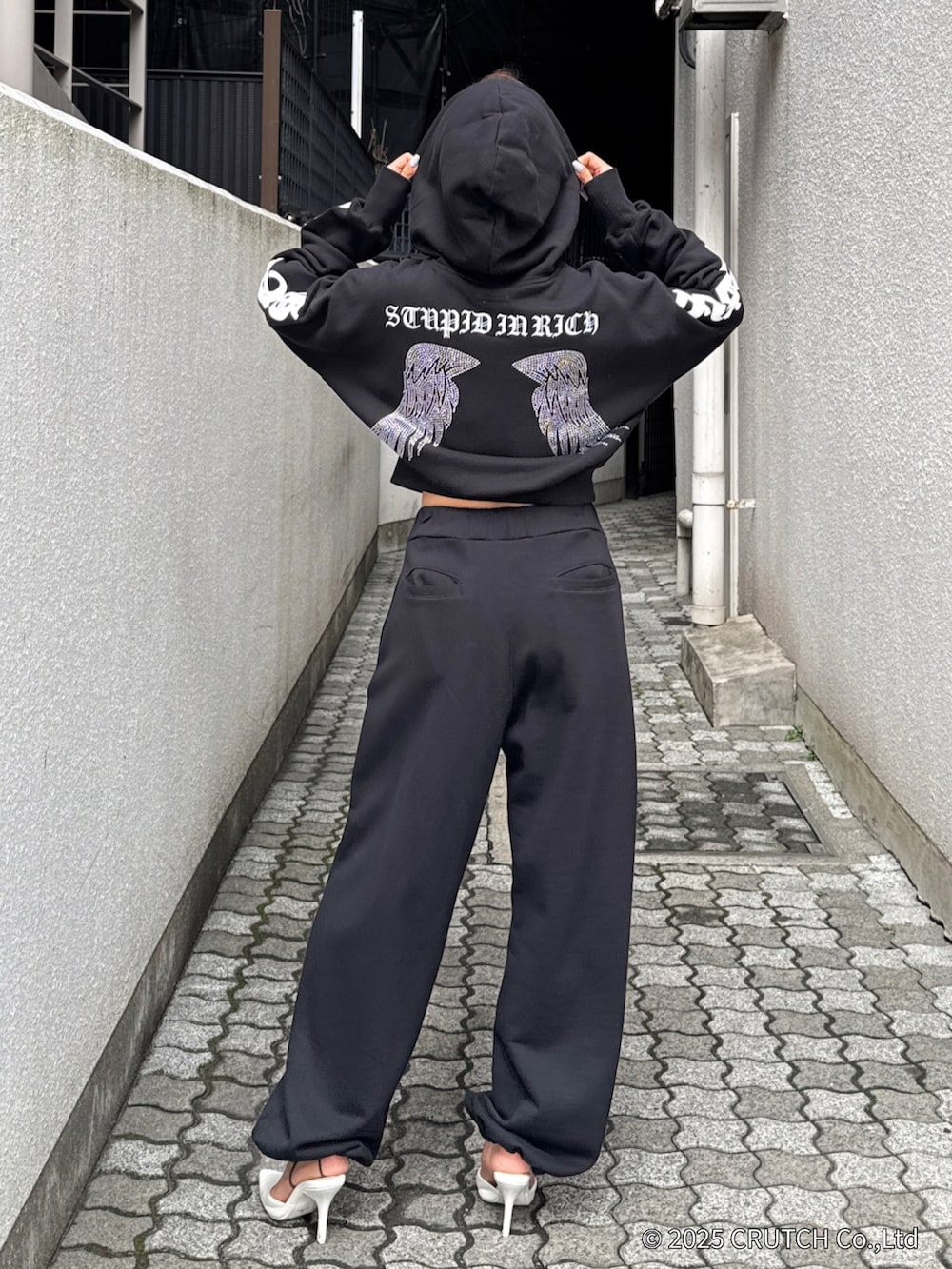 ブラック系のパーカー、ブラック系のその他パンツ、ホワイト系のパンプスを着用したレディースの秋コーディネートの4枚目の写真