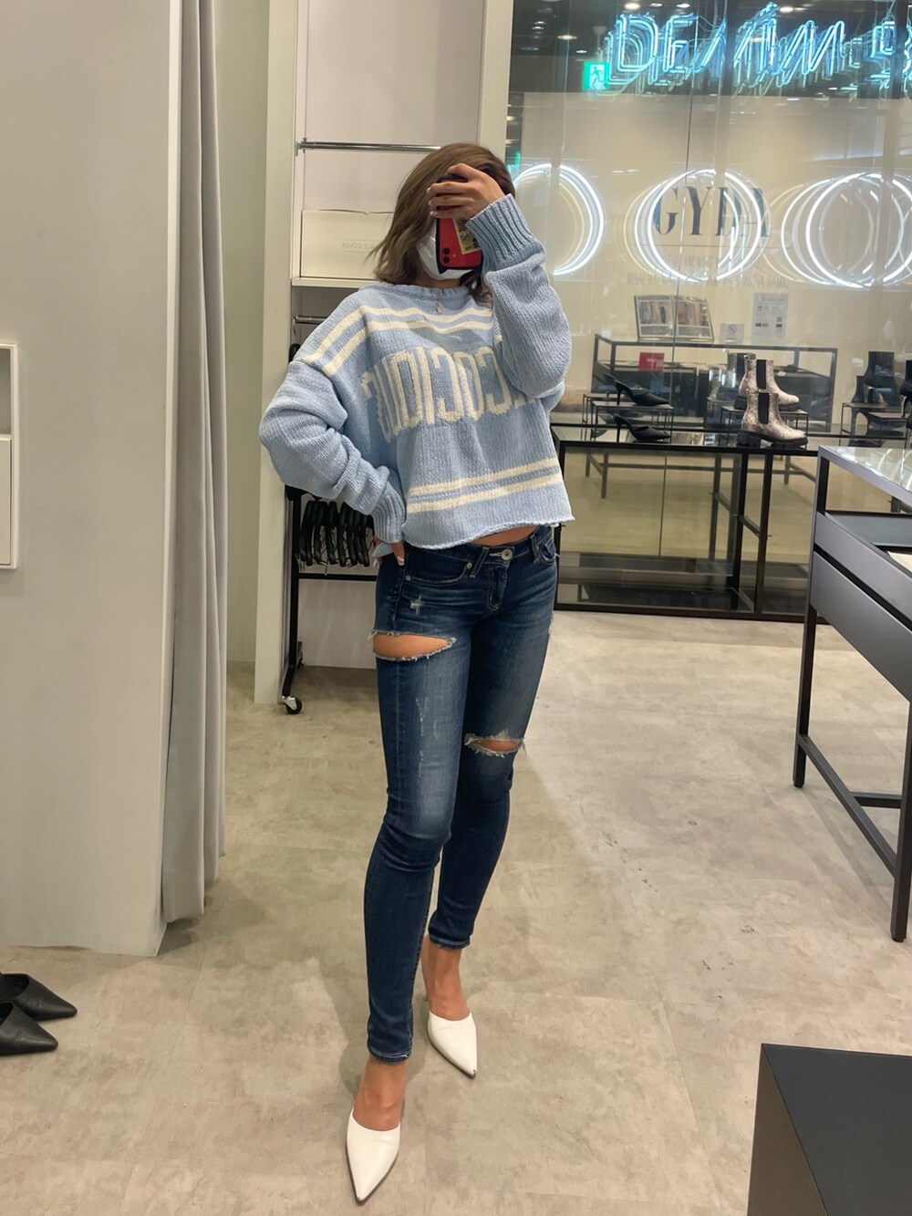 ブルー系のニット/セーター、ブルー系のデニムパンツ、ホワイト系のパンプスを着用したレディースの冬コーディネートの3枚目の写真