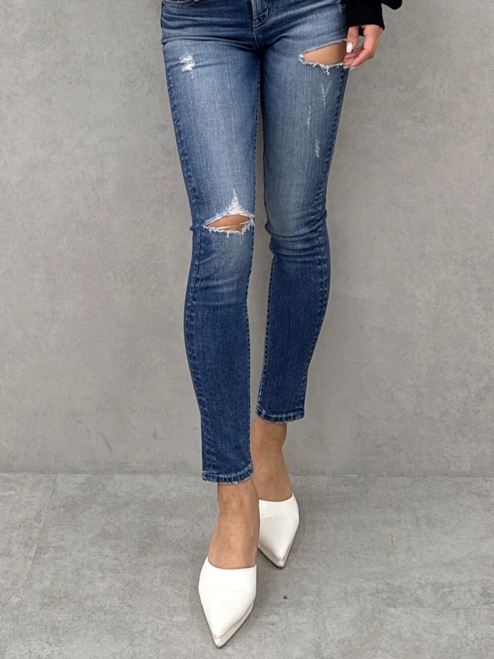 ブラック系のニット/セーター、ブルー系のデニムパンツ、ホワイト系のパンプスを着用したレディースの冬コーディネートの6枚目の写真