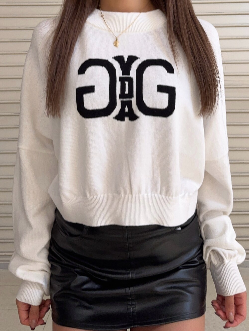 ホワイト系のニット/セーター、ブラック系のスカート、ブラック系のブーツを着用したレディースの秋コーディネートの5枚目の写真