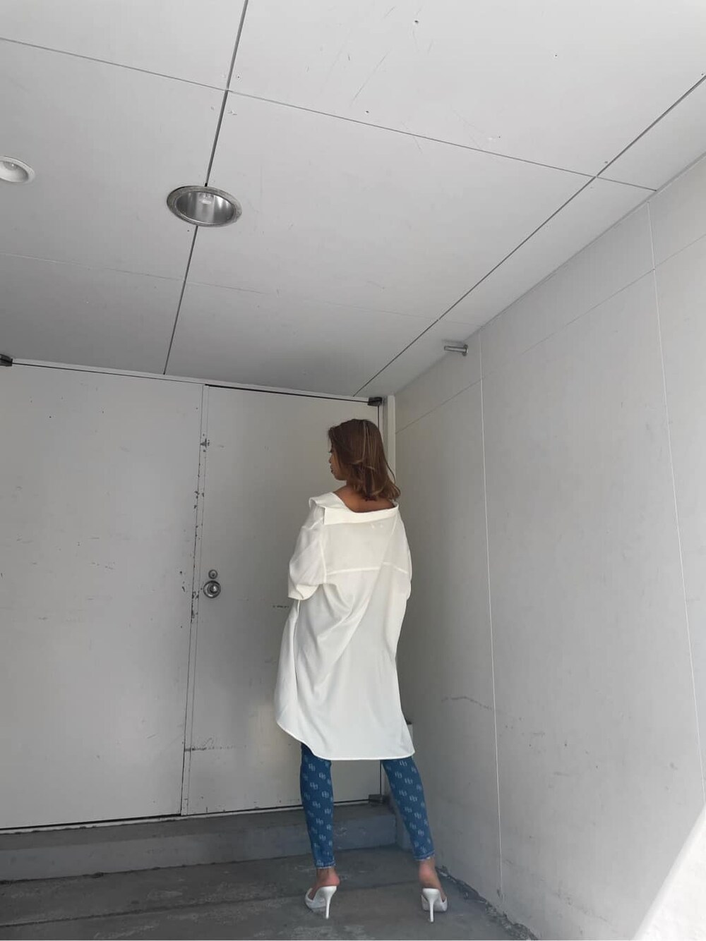 ホワイト系のパンプス、ホワイト系のキャミソール、ホワイト系のシャツ/ブラウスを着用したレディースの春コーディネートの3枚目の写真